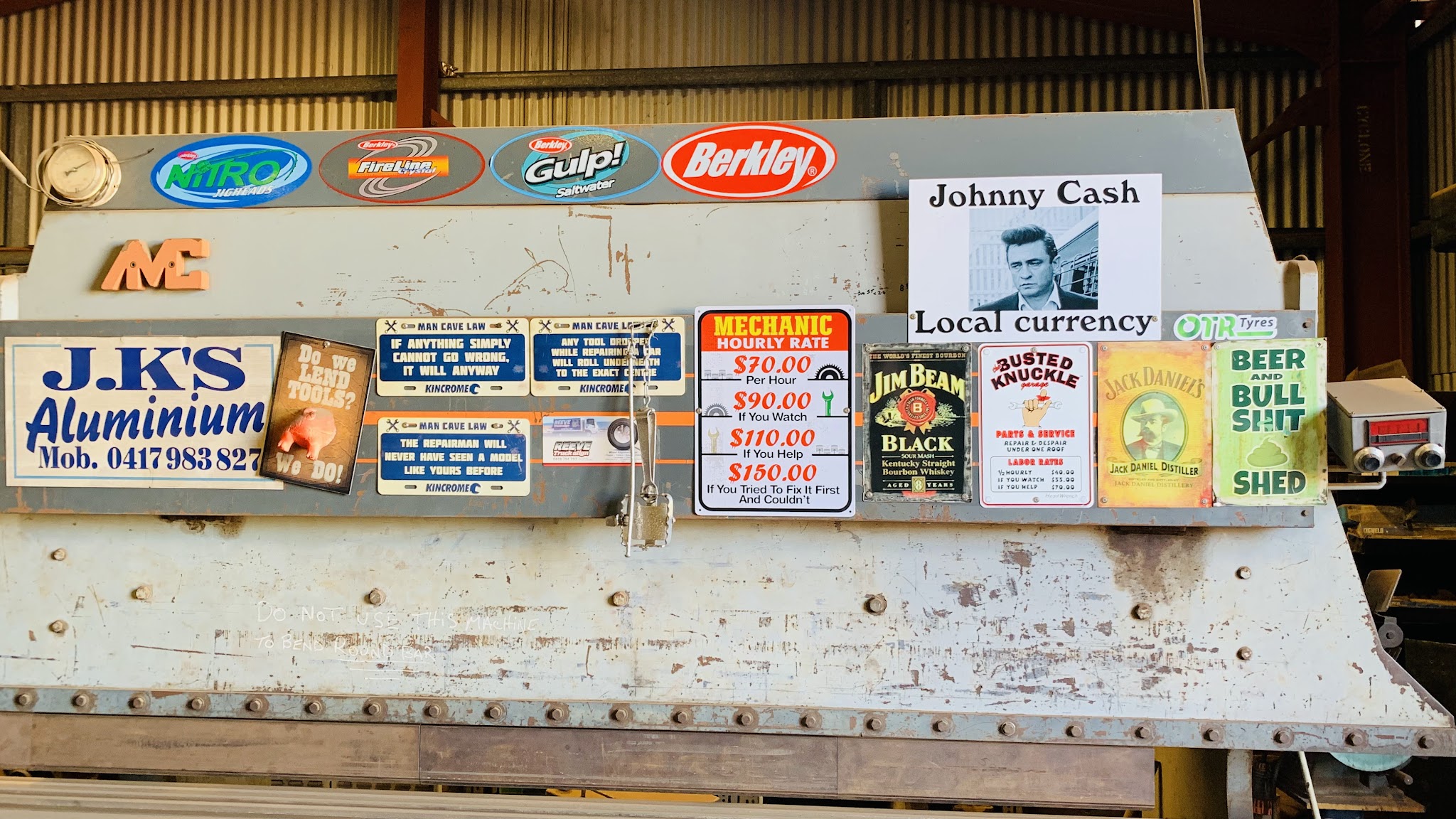 The sign wall inside the J.K'S Aluminium workshop, with the business signboard in navy and cream